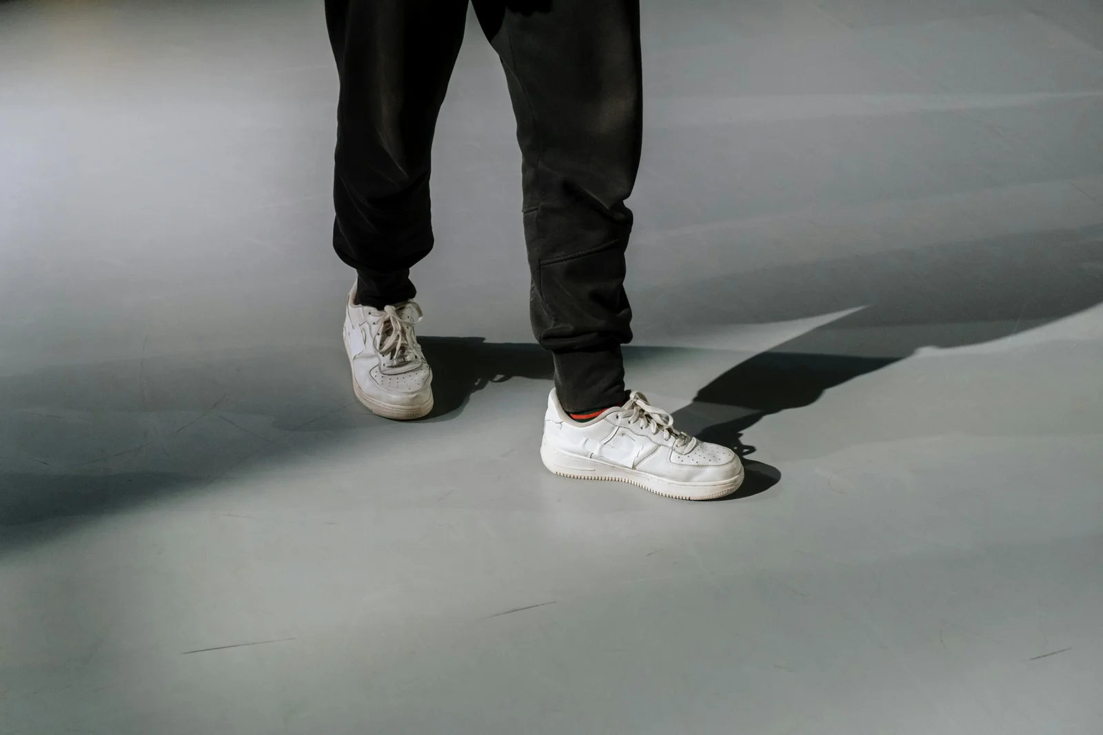 Persona limpiando zapatillas de cerca, cuidado del calzado blanco.