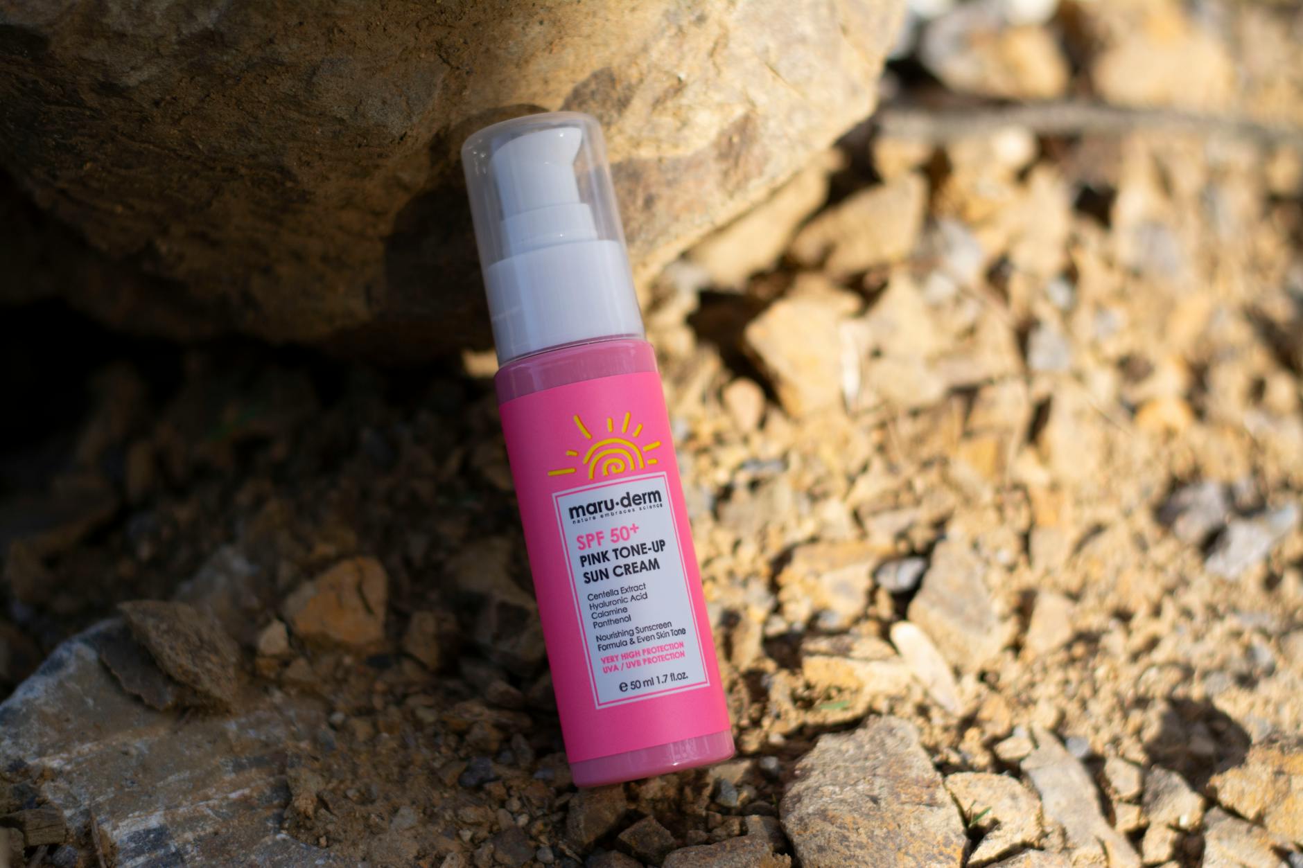 Bano luminoso con cosmeticos sencillos, toalla blanca y crema hidratante sin marcas visibles.