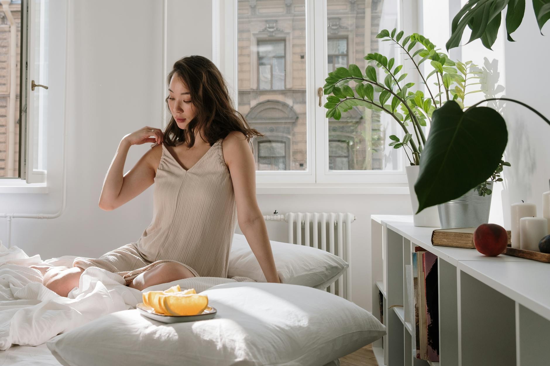 Mujer adulta preparando infusion en una cocina luminosa de manana con gesto tranquilo y ropa comoda.