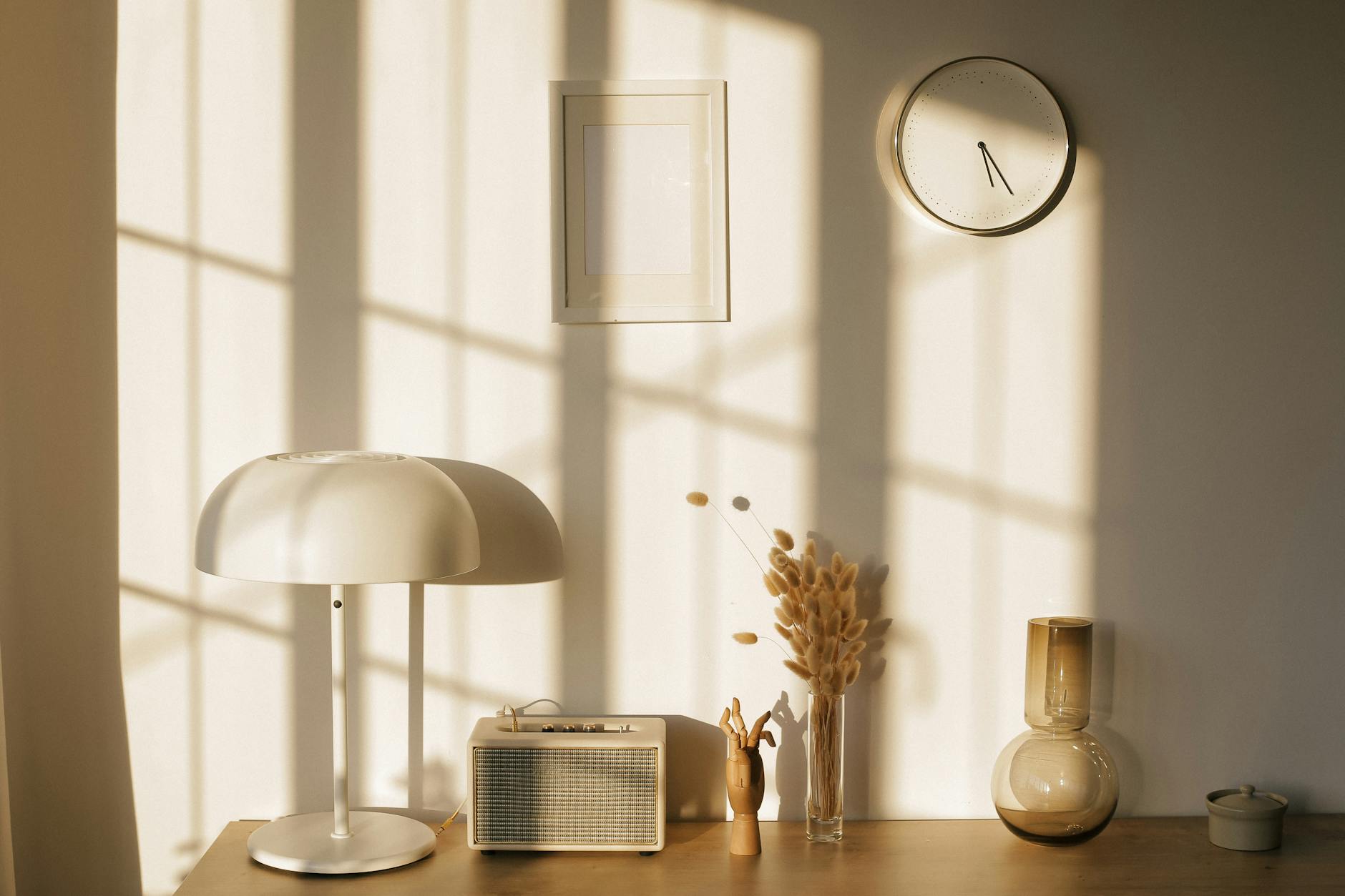 Dormitorio adulto con ropa de cama de lino, mesilla de madera, flores discretas y luz suave.